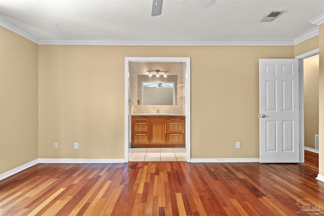 unfurnished bedroom with ornamental molding, sink, and light wood-type flooring