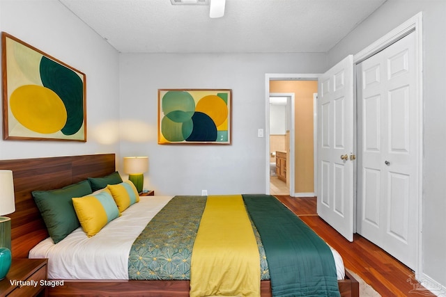 bedroom featuring a closet, wood-type flooring, and a textured ceiling