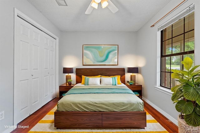 bedroom with ceiling fan, wood-type flooring, a closet, and a textured ceiling