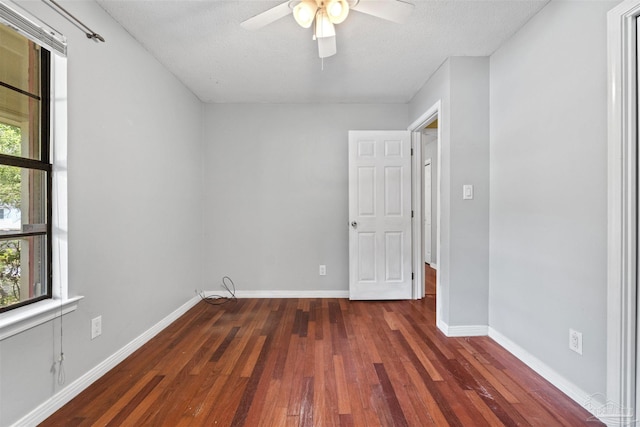 empty room featuring a textured ceiling, dark hardwood / wood-style floors, and ceiling fan