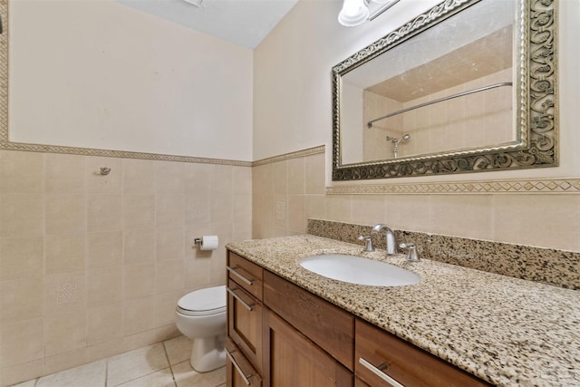 bathroom featuring tile walls, vanity, tile patterned floors, toilet, and walk in shower