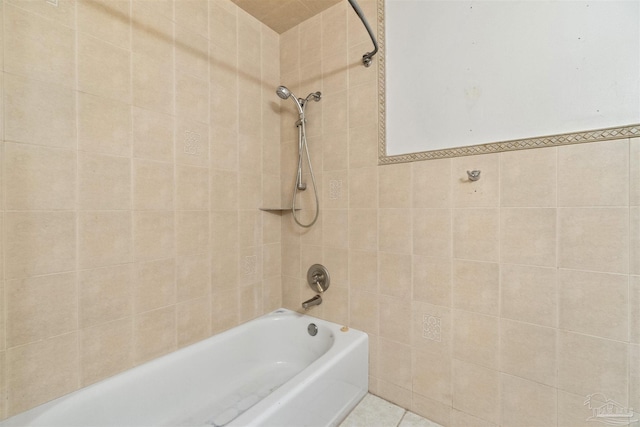 bathroom with tile walls, tiled shower / bath combo, and tile patterned floors