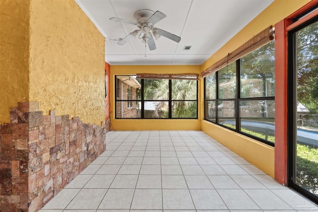 unfurnished sunroom featuring ceiling fan