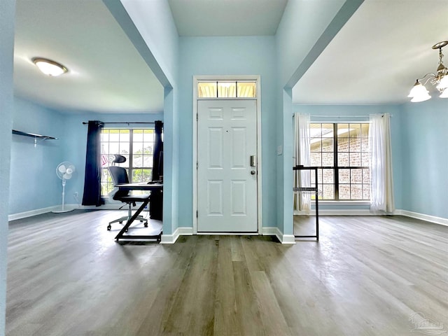 entryway with an inviting chandelier and wood-type flooring