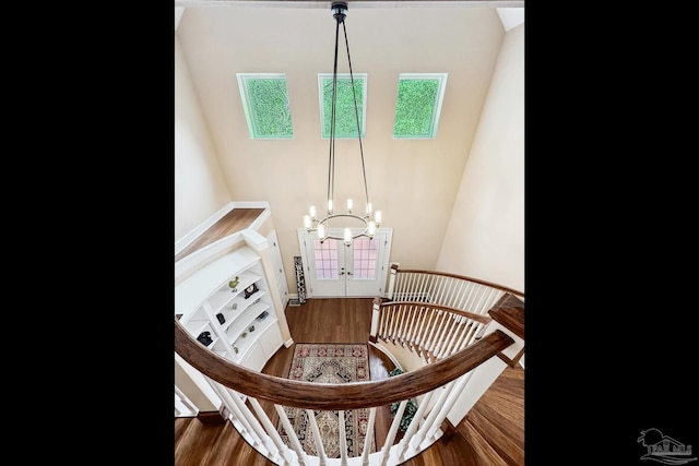 stairs featuring wood-type flooring and a chandelier