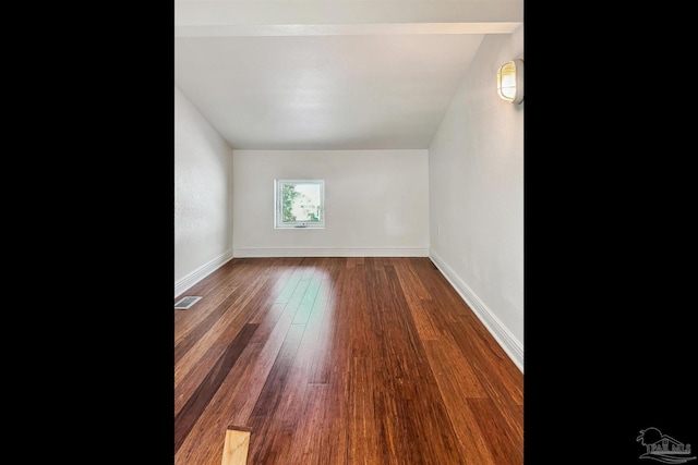 bonus room featuring vaulted ceiling and dark wood-type flooring