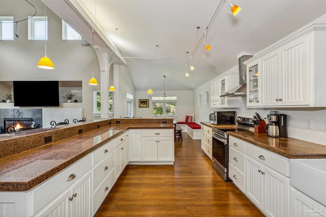 kitchen featuring pendant lighting, wall chimney exhaust hood, white cabinetry, appliances with stainless steel finishes, and dark hardwood / wood-style flooring