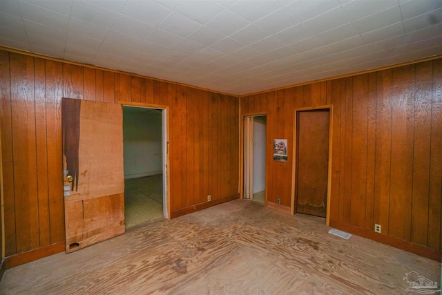 unfurnished room featuring wood walls