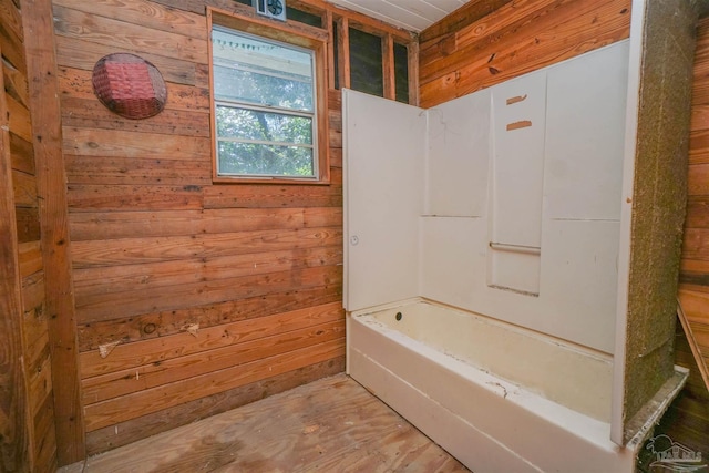 full bathroom with shower / tub combination and wooden walls