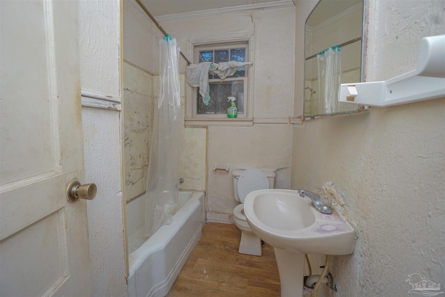 full bathroom with crown molding, a textured wall, toilet, shower / tub combo, and wood finished floors