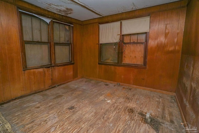 empty room with wood walls and wood-type flooring