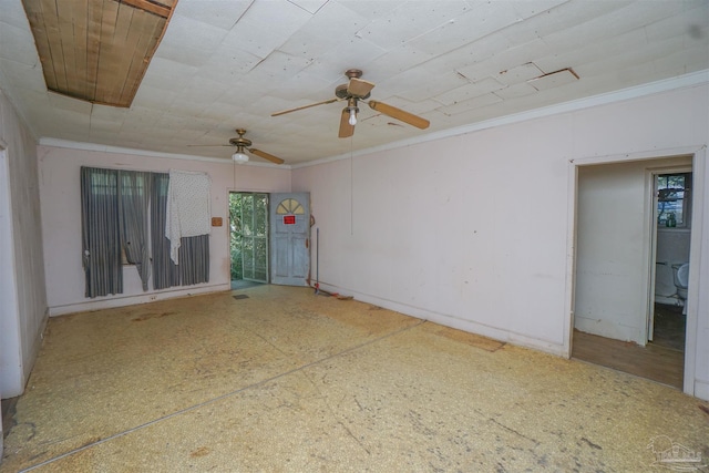 spare room with attic access, crown molding, and baseboards