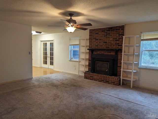 unfurnished living room featuring carpet floors, french doors, a brick fireplace, a textured ceiling, and baseboards