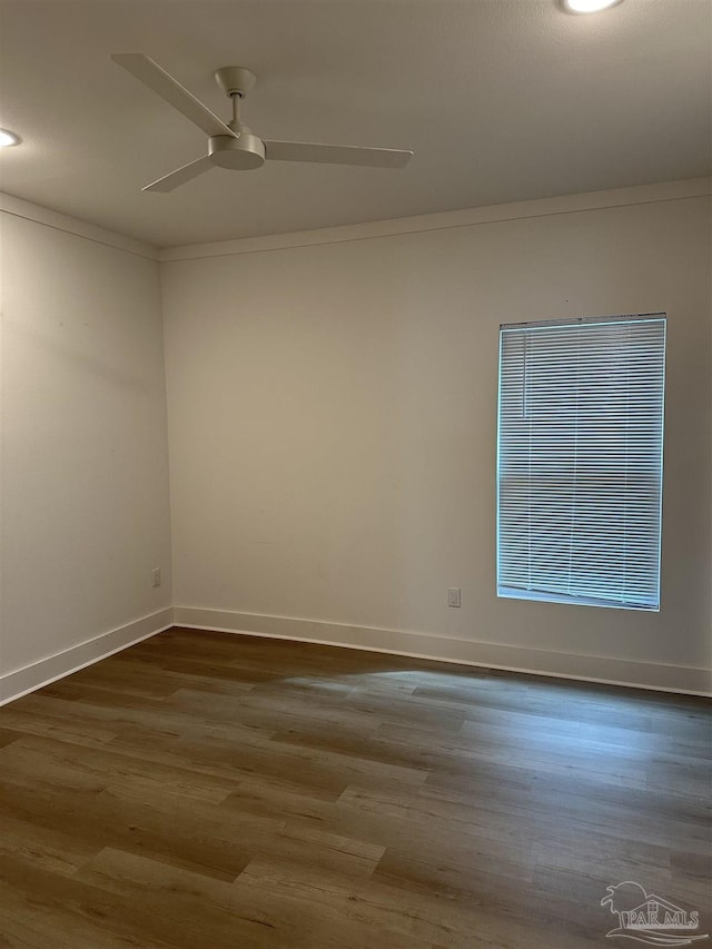 unfurnished room featuring ceiling fan, ornamental molding, dark wood-style floors, and baseboards