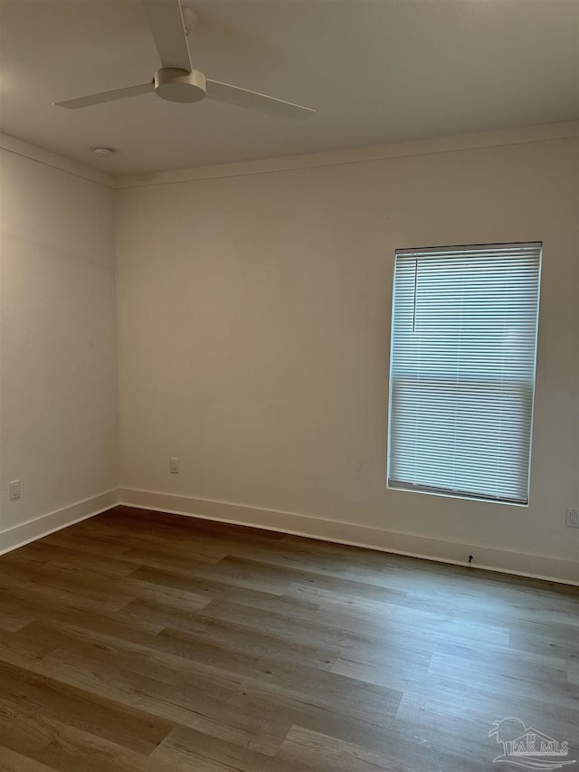 unfurnished room featuring baseboards, ceiling fan, ornamental molding, and wood finished floors