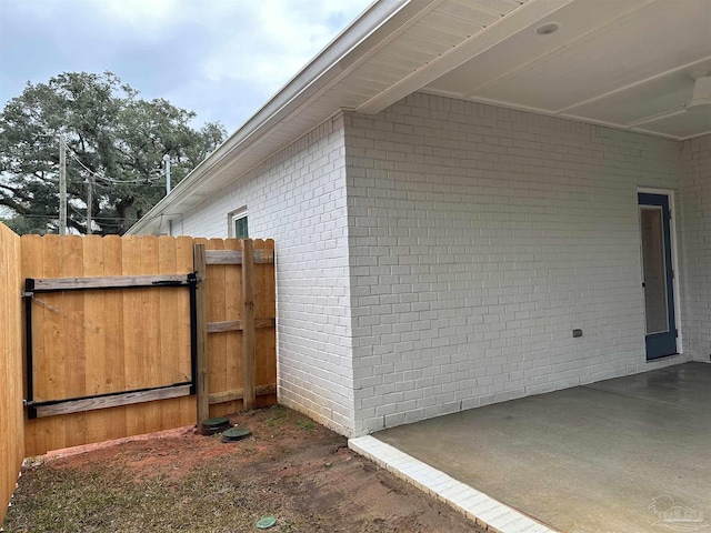 view of side of property with fence and a gate