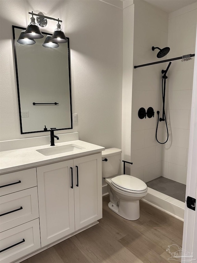 full bathroom with toilet, a shower stall, wood finished floors, and vanity