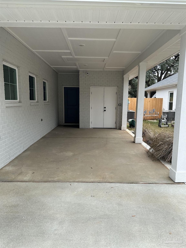 view of patio with an attached carport and fence