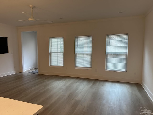 unfurnished room with ornamental molding, light wood-style floors, baseboards, and a ceiling fan