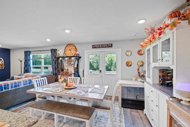 dining room with a textured ceiling, light hardwood / wood-style flooring, and a wealth of natural light