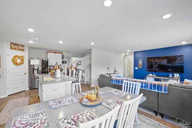 dining space with sink and light hardwood / wood-style flooring