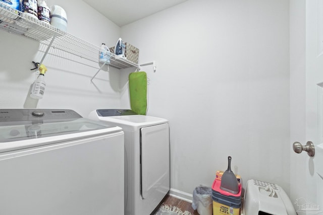 clothes washing area featuring dark hardwood / wood-style floors and separate washer and dryer