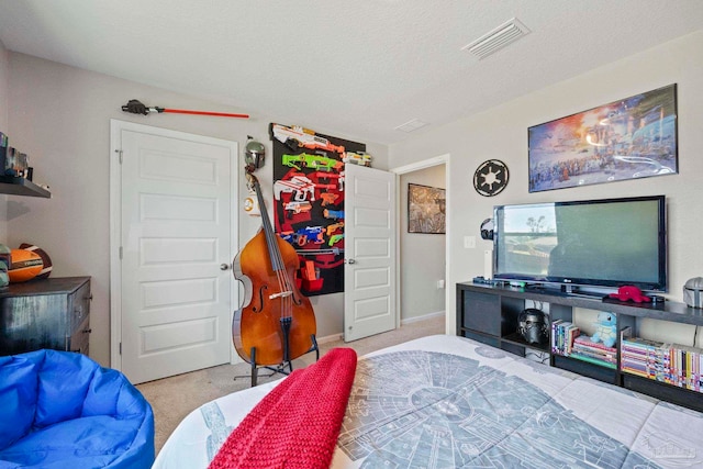 bedroom with a textured ceiling and light colored carpet