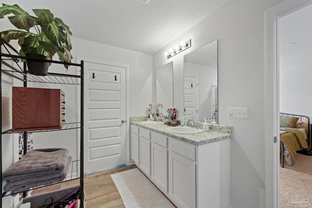 bathroom featuring vanity, a textured ceiling, and hardwood / wood-style floors