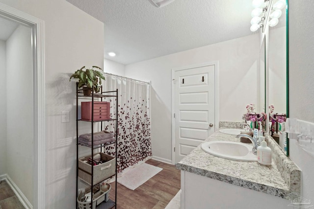 bathroom with vanity, wood-type flooring, a textured ceiling, and a shower with shower curtain