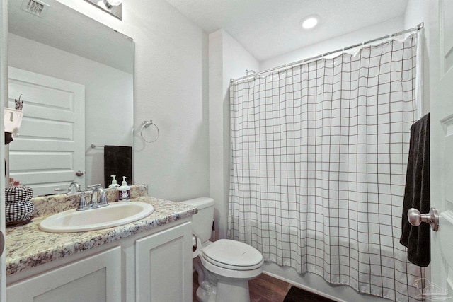 full bathroom with a textured ceiling, hardwood / wood-style flooring, shower / bathtub combination with curtain, toilet, and vanity