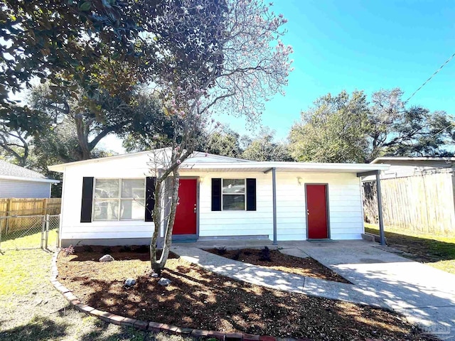 view of front of property featuring concrete driveway and fence