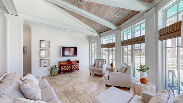 living room featuring high vaulted ceiling, beamed ceiling, wooden ceiling, baseboards, and stone tile flooring