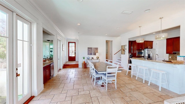 dining space featuring visible vents, crown molding, and stone tile flooring