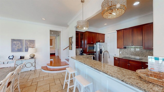 kitchen with an inviting chandelier, light stone counters, decorative backsplash, stone tile floors, and appliances with stainless steel finishes
