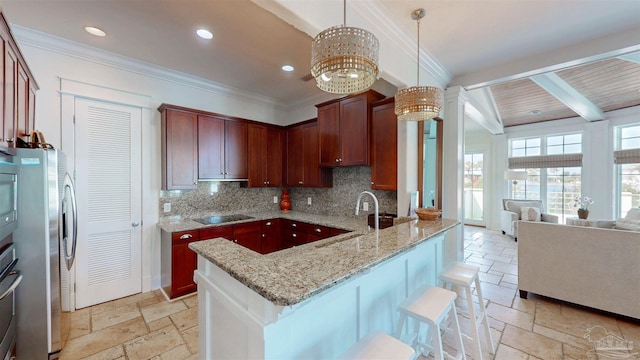 kitchen featuring tasteful backsplash, a sink, stone tile flooring, and stainless steel appliances