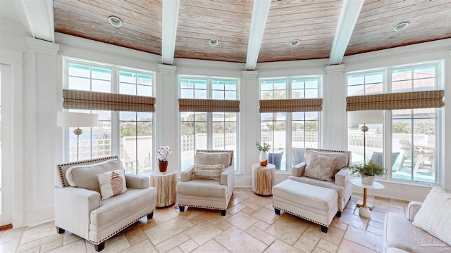 living room with stone tile flooring, baseboards, beamed ceiling, and wood ceiling