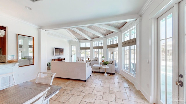 living area with ornamental molding, visible vents, vaulted ceiling with beams, baseboards, and stone tile flooring