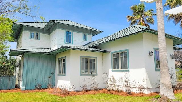 view of home's exterior featuring fence, metal roof, and a standing seam roof