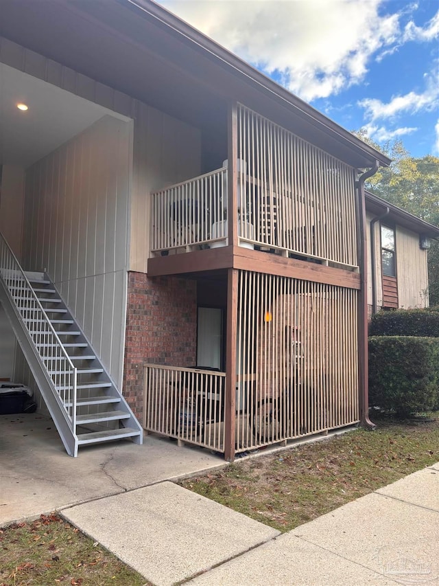 view of property exterior featuring stairs and brick siding