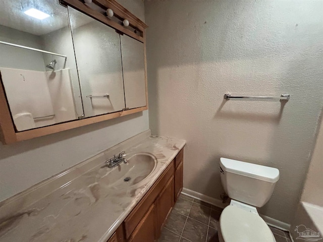 full bath featuring toilet, vanity, tile patterned flooring, baseboards, and walk in shower