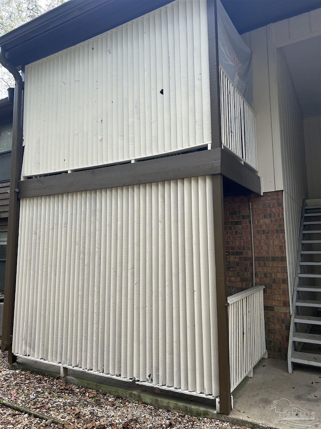 view of property exterior with a balcony and stairs