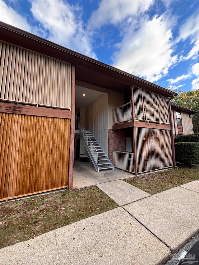 exterior space with a balcony and brick siding