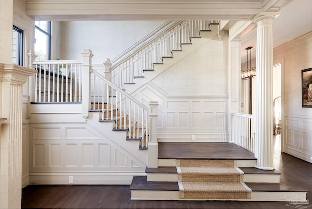 stairway featuring hardwood / wood-style flooring, crown molding, and a notable chandelier