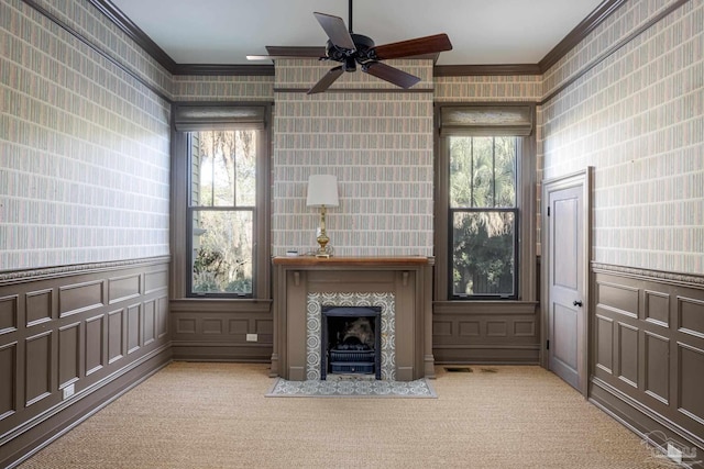 unfurnished living room featuring light carpet, a fireplace, a wealth of natural light, and crown molding