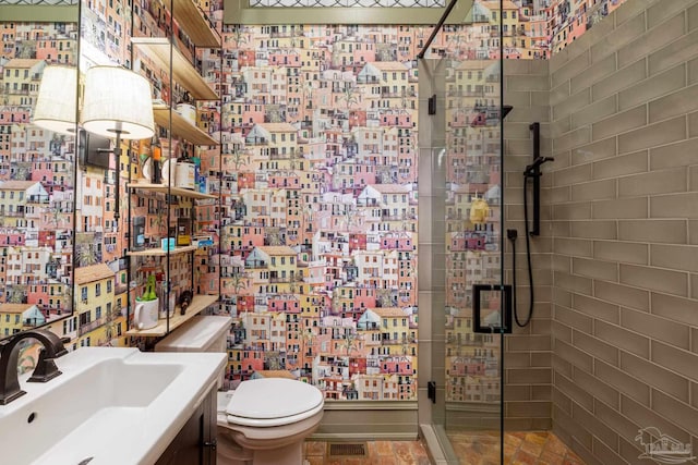 bathroom with vanity, toilet, and a shower with shower door