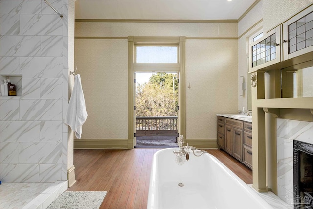 bathroom with a high end fireplace, crown molding, hardwood / wood-style floors, vanity, and independent shower and bath