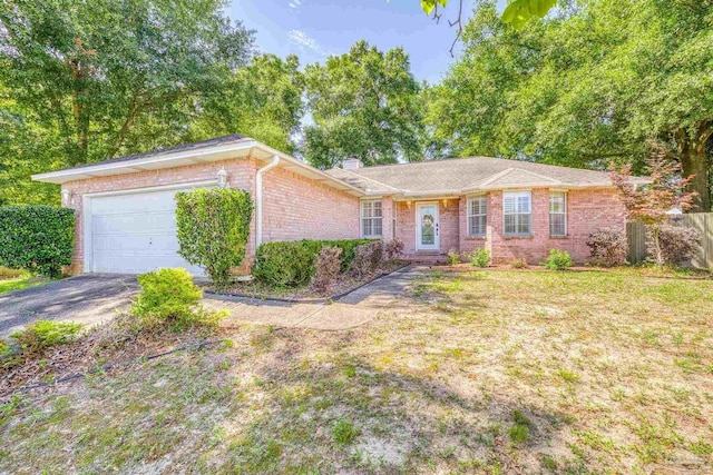 single story home with brick siding, a chimney, aphalt driveway, an attached garage, and a front yard