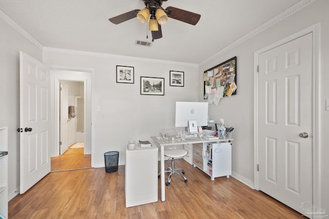 home office featuring baseboards, visible vents, crown molding, and light wood finished floors