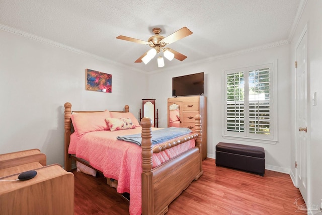 bedroom featuring a textured ceiling, ceiling fan, wood finished floors, baseboards, and crown molding