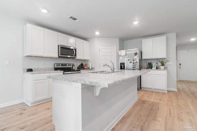 kitchen with white cabinetry, a center island with sink, and stainless steel appliances